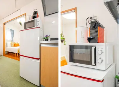 a kitchen with a white refrigerator and a microwave at KYARA Hotel 402 in Tokyo