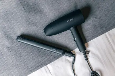 a black hair dryer sitting on top of a bed at YOYOGI PARK HOTEL in Tokyo
