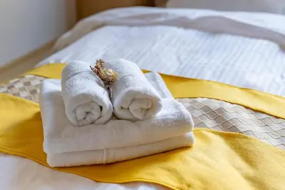 a pile of towels sitting on top of a bed at YOYOGI PARK HOTEL in Tokyo