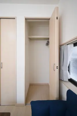a room with a closet with a blue couch and a window at CON-TWO 201 in Tokyo