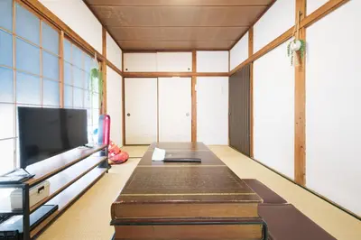 a living room with a table and a tv at Push house \u6d66\u5b89 in Tokyo
