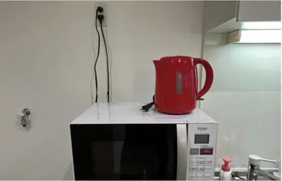 a red jug sitting on top of a microwave at Tokyo Stay \u821e in Tokyo