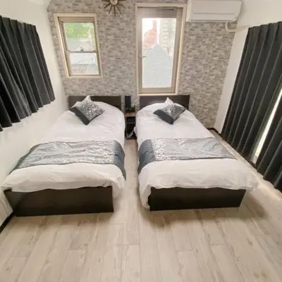 two beds in a bedroom with two windows at 54, Tateishi, Entire house for rent, \u7acb\u77f3 in Tokyo