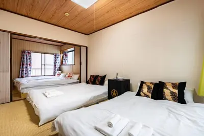 a room with three beds with white sheets at Max12PPL!7m walk from station!Japan style house! in Tokyo