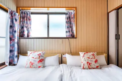 two beds with pillows in a bedroom with a window at Max12PPL!7m walk from station!Japan style house! in Tokyo