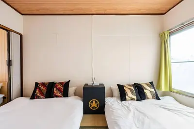 two beds in a room with white walls and windows at Max12PPL!7m walk from station!Japan style house! in Tokyo