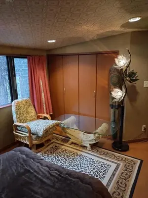a bedroom with a bed and a chair and a rug at Stage YOU in Tokyo