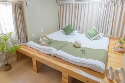 a large bed in a room with a wooden table at \u685c\u306e\u5ddd16 \u6c60\u888b\u4e00\u6238\u5efa \u6c60\u888b\u99c5 5\u5206 2-11\u4eba\u4e28Ikebukuro Villa Ikebukuro 5 minutes 2-11 people in Tokyo