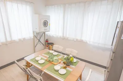 a dining room with a table and chairs and a microwave at \u685c\u306e\u5ddd16 \u6c60\u888b\u4e00\u6238\u5efa \u6c60\u888b\u99c5 5\u5206 2-11\u4eba\u4e28Ikebukuro Villa Ikebukuro 5 minutes 2-11 people in Tokyo