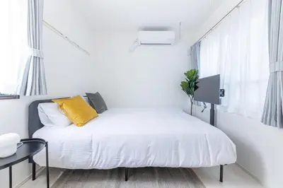 a white bedroom with a bed and a table at 67 Apt Koenji Tokyo in Tokyo