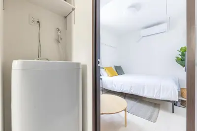 a small room with a bed and a refrigerator at 67 Apt Koenji Tokyo in Tokyo