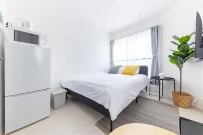 a white bedroom with a bed and a tv at 67 Apt Koenji Tokyo in Tokyo