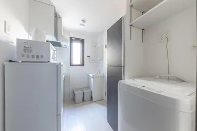a small white kitchen with a refrigerator and a washer at APB\u9ad8\u5186\u5bfa in Tokyo