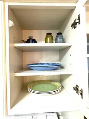 a white shelf with plates and vases on it at Kyo Sai \u6d45\u83492F\u6d45\u8349\u5bfa\u307e\u3067\u5f92\u6b65\u7d0410\u5206 in Tokyo