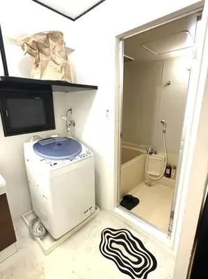 a small bathroom with a washing machine in a room at Kyo Sai \u6d45\u83492F\u6d45\u8349\u5bfa\u307e\u3067\u5f92\u6b65\u7d0410\u5206 in Tokyo