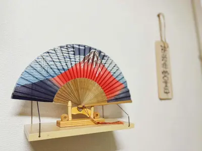a small wooden fan on a shelf with a thermometer at TOKYOSTYLE in Tokyo