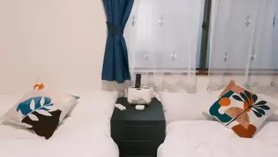 a bedroom with two beds and a table with a phone at TOKYOSTYLE in Tokyo