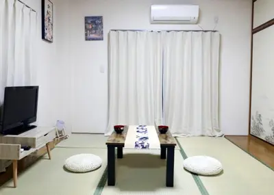 a living room with a coffee table in front of a window at TOKYOSTYLE in Tokyo