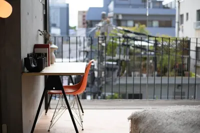 a table and a chair in front of a balcony at GRASS BLDG 401 in Tokyo
