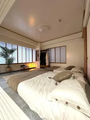 a large bedroom with a large white bed with windows at Kyo Sai \u6d45\u83493F\u3000120\u33a1\u8d85\u3048\u6d45\u8349\u5bfa\u307e\u3067\u5f92\u6b65\u7d0410\u5206 in Tokyo