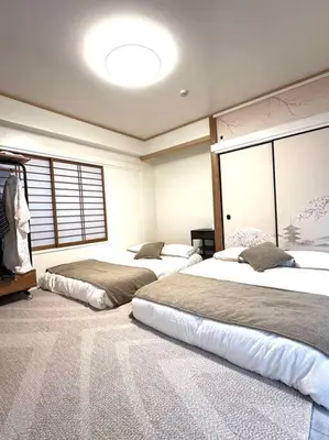 a bedroom with two beds and a large window at Kyo Sai \u6d45\u83493F\u3000120\u33a1\u8d85\u3048\u6d45\u8349\u5bfa\u307e\u3067\u5f92\u6b65\u7d0410\u5206 in Tokyo