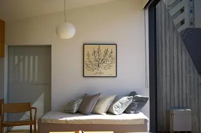 a living room with a couch and a picture on the wall at GRASS BLDG 501 in Tokyo