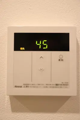 a digital clock on a wall with a clock on it at IXO Ts3 in Tokyo