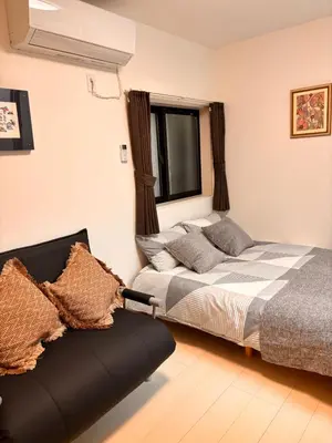 a bedroom with a bed and a couch in it at IXO Ts3 in Tokyo