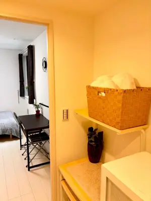 a kitchen with a table and a basket on the wall at IXO Ts3 in Tokyo