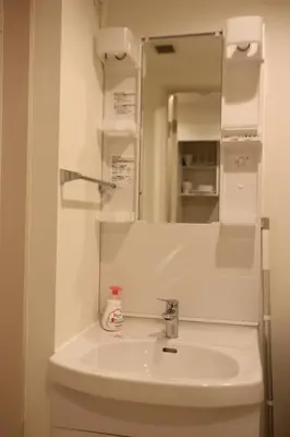 a white bathroom with a sink and a mirror at IXO Ts3 in Tokyo