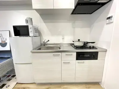 a small kitchen with a sink and a microwave at Nishi-Ike Apartment Room 1 in Tokyo