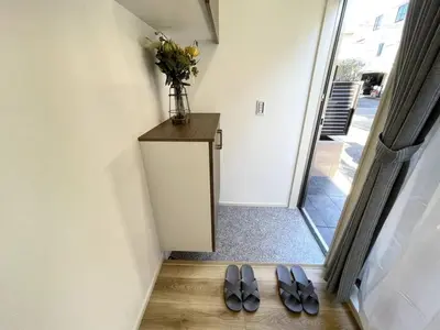 two pairs of slippers on the floor in a hallway with a vase on at Nishi-Ike Apartment Room 1 in Tokyo