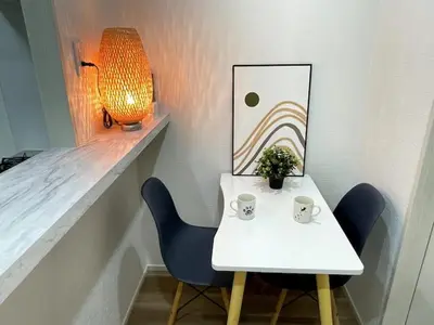 a white table with two chairs and a picture on a wall at Nishi-Ike Apartment Room 2 in Tokyo