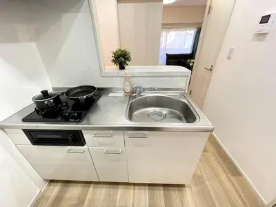 a kitchen counter with a sink and a stove at Nishi-Ike Apartment Room 2 in Tokyo