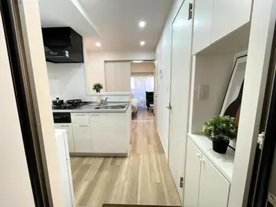 a white kitchen with a sink and a counter at Nishi-Ike Apartment Room 2 in Tokyo