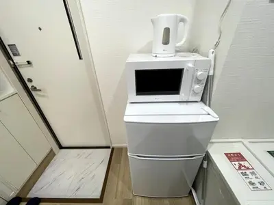 a microwave sitting on top of a toilet in a room at Nishi-Ike Apartment Room 2 in Tokyo