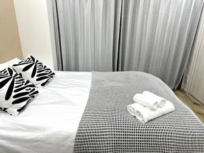 a bed with two folded towels on top of it at Nishi-Ike Apartment Room 3 in Tokyo