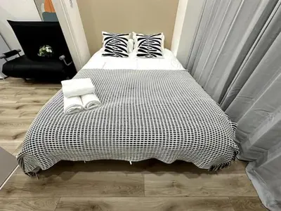 a bed with black and white sheets and pillows at Nishi-Ike Apartment Room 3 in Tokyo