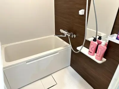 a bathroom with a white tub and pink shampoo bottles at Nishi-Ike Apartment Room 3 in Tokyo