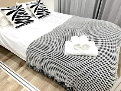 a bed with two white towels on top of it at Nishi-Ike Apartment Room 3 in Tokyo