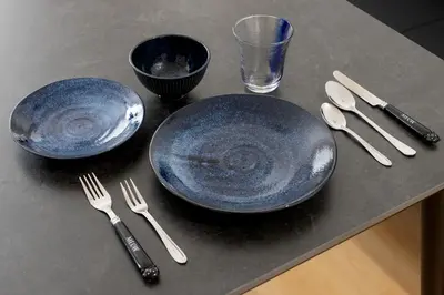 two blue plates and utensils sitting on a table at Kagurazaka City House - \u795e\u697d\u5742\u30b7\u30c6\u30a3\u30cf\u30a6\u30b9 in Tokyo