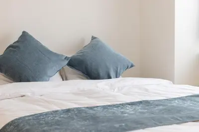 a bed with two blue pillows on top of it at Kagurazaka City House - \u795e\u697d\u5742\u30b7\u30c6\u30a3\u30cf\u30a6\u30b9 in Tokyo
