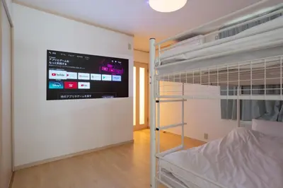 a bedroom with a bunk bed with a tv on the wall at Kagurazaka City House - \u795e\u697d\u5742\u30b7\u30c6\u30a3\u30cf\u30a6\u30b9 in Tokyo