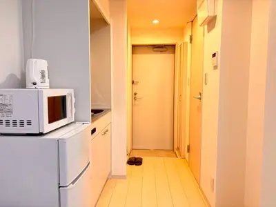 a kitchen with a microwave on top of a refrigerator at IXO Ts2 in Tokyo