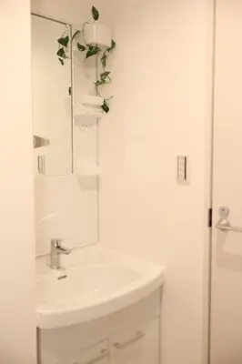 a white bathroom with a sink and a mirror at IXO Ts2 in Tokyo