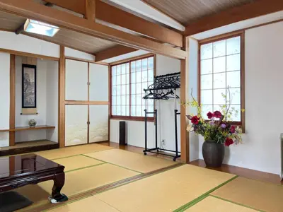 a living room with a piano and a vase of flowers at \u677f\u6771\u30d3\u30eb in Tokyo