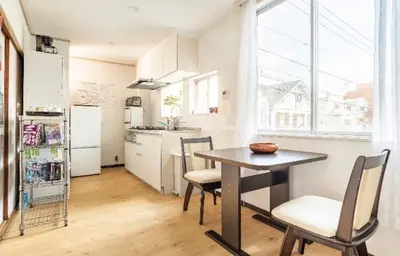 a kitchen with a table and chairs and a refrigerator at \u677f\u6771\u30d3\u30eb in Tokyo