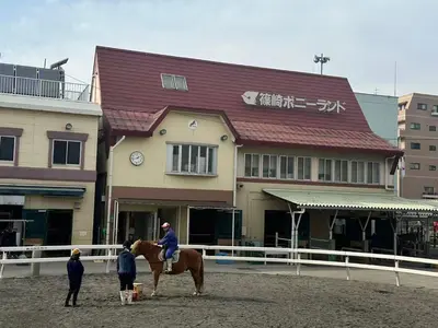 a person riding a horse in front of a building at \u677f\u6771\u30d3\u30eb in Tokyo
