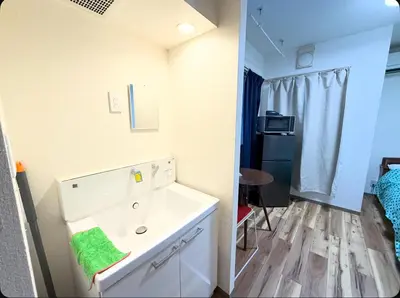 a bathroom with a white dresser with a green towel at Small stay in Tokyo in Tokyo