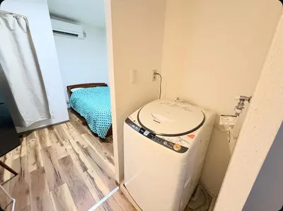 a small room with a washing machine in a room at Small stay in Tokyo in Tokyo